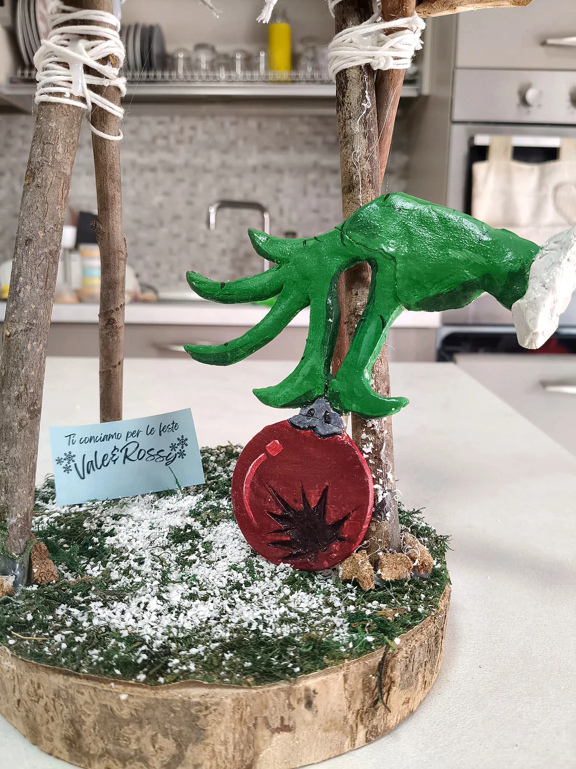 Decorazione natalizia artigianale allestita su una base con neve finta e legno